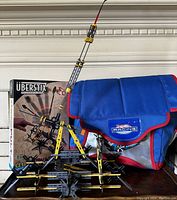 Vintage Uberstix construction toy set partially assembled with original box, alongside blue Hotwheels Racing bag with red trim and logo patch.