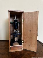Vintage Mayflower microscope inside open wooden box showing full unit and drawer beneath