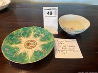Top view of the green cabbage pattern dish with peaches and bats, showing detailed colors and design, accompanied by the bowl and note with measurements.
