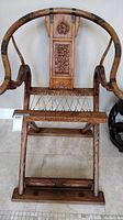 Front view of folding chair showing overall design and carved backrest