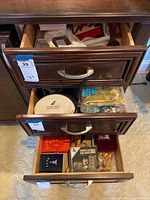 Drawers open showing assorted jewelry boxes, souvenir items including a China plate and decorative satchels.