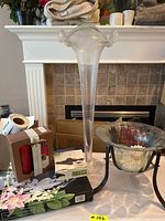 Tall clear glass vase and round glass bowl on stand with boxed mug set on table