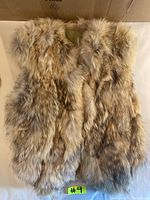 Photo of front side of vintage fur vest laid flat showing natural light brown multi-tone fur.