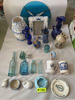 Photo showing full lot of vintage glass bottles, ceramic pieces, collectible mugs and decorative items