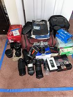 Overview of cameras, lenses, flash, bags and boxes on floor