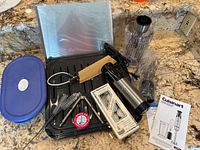 View of all items including blender, pans, bottle cleaners, candles, crab cracker, and container on countertop