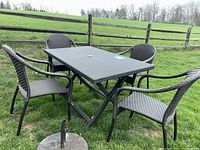 Overall set on grass showing table, four chairs, and umbrella stand