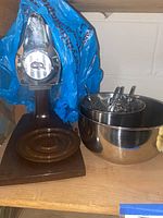Sunbeam stand mixer with stainless steel bowls and beaters on a wooden base