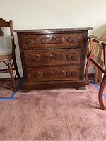 Front view of vintage dresser showing three drawers and wood finish