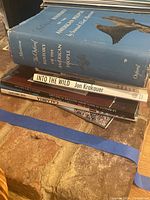 Pile of books including 'A History of the American People' and 'Into the Wild'