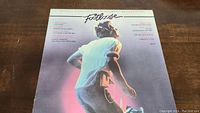 Front cover of Footloose soundtrack LP vinyl record showing man dancing with title and track list