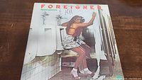 Front cover of Foreigner's 'Head Games' vinyl record showing a woman in a restroom stall.