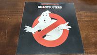 Front cover of the Ghostbusters soundtrack featuring ghost logo on black background.