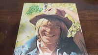 Front cover of the vinyl album showing John Denver smiling in glasses and a hat.