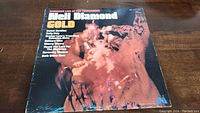 Front cover of Neil Diamond Gold album showing a blurred image of Neil Diamond live on stage with lighting effects, artist name and album title.