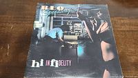 Front cover of REO Speedwagon Hi Infidelity album featuring a man and woman in a room setting.
