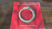 Front cover of The Alan Parsons Project vinyl album Vulture Culture showing serpent eating its tail on red background