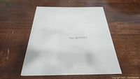 Front side of The Beatles White Album vinyl record cover, white with The Beatles text.