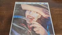 Front cover of The Cars vinyl album featuring woman behind steering wheel.