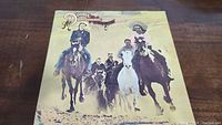 Front cover of The Doobie Brothers Stampede vinyl album showing four men riding horses.