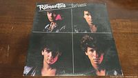 Front cover of The Romantics 'In Heat' vinyl album showing four portraits of band members on a dark background with the title in white text.