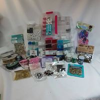 Overview photo showing whole lot consisting of beads, ribbons, buttons, pins, hair clips, and crafting glitters.