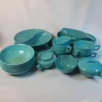 Full view of the Melmac dish set showing bowls, cups, serving platters, gravy boat, condiment bowl, cream and sugar dishes in turquoise.