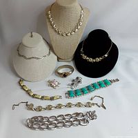 Full view showing various Coro jewelry pieces including necklaces, bracelets, brooches, and rings arranged on display stands and flat surface.