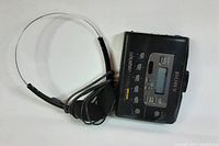 Black Sony Walkman cassette player with earphones showing top view and control buttons.