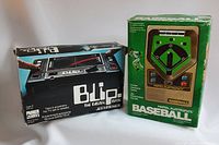 Photo showing Mattel Electronics Baseball and Parker Blip electronic games in original boxes.
