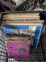 View of stacked vinyl records with original covers including Ella Fitzgerald in a basket