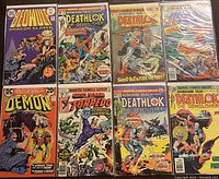 Photo shows 8 comics laid out including Beowulf Dragon Slayer #1, The Demon, Torpedo, multiple Deathlok issues, and Fantastic Four.