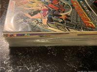 Front and stacked side view of Cougar comic book showing colorful cover art with characters in action scenes stored in plastic sleeve.