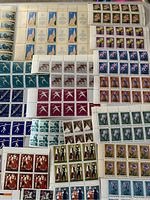 A collection of multiple sheets of unused postage stamps showing flowers, sports figures, birds, and cultural designs from Bulgaria and Scandinavian countries.