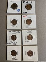 Front view of 8 one cent coins mounted individually in holders showing different years and errors such as double date, off center, and double 6.
