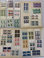 Photo showing one open page of the album with blocks of unused stamps in different colors, including green, pink, blue, brown, and red featuring various historic and symbolic designs.