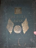 Image of book cover showing embossed text 'Russia Japan' and symbolic flags with gold-colored decoration.