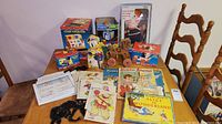 Overview of boxed vintage Fisher Price toys and accompanying children's books and cards on table.