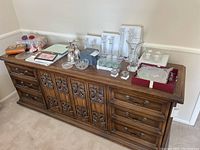 Wide view of various crystal items including vases, bowls, and candle holders on top of wooden sideboard