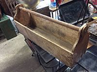 Side view of the handmade wooden carpenter's tool box showing its aged wood and dovetail joints.