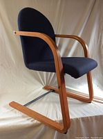 Full view of black upholstered IKEA chair with bentwood arms and cantilever base