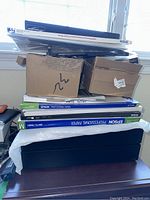 Overall view of printer, paper packs and ink cartridges stacked