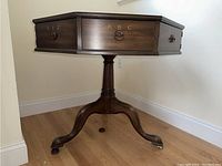 Front view showing drawers labeled XYZ and ABC, fluted pedestal and splayed legs with casters.