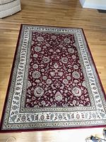 Full view of the rectangular rug on a wooden floor showing the entire design and border.