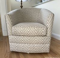 Front view of chair showing barrel back, seat cushion and chevron pattern