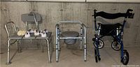 Photo of bath chair, portable commode, and metal grab bars on a bench in a basement area.