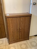 Full front view of the laminate cabinet with two doors and handles.