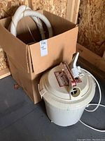 Full view of Kenmore carpet cleaning system main unit next to box containing hose.