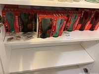 Shelf with Coca Cola glasses in original McDonald's red packaging and several pins in plastic sleeves