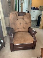 Full front view of the brown corduroy and dark brown vinyl recliner chair showing the seat cushion, button tufting on backrest, and vinyl armrests.